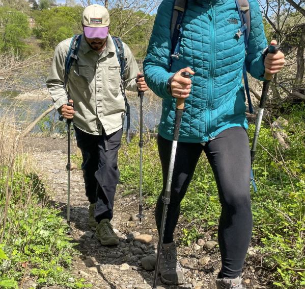 Hikers using poles that can be used as winter trekking poles for skiing or snowshoeing.